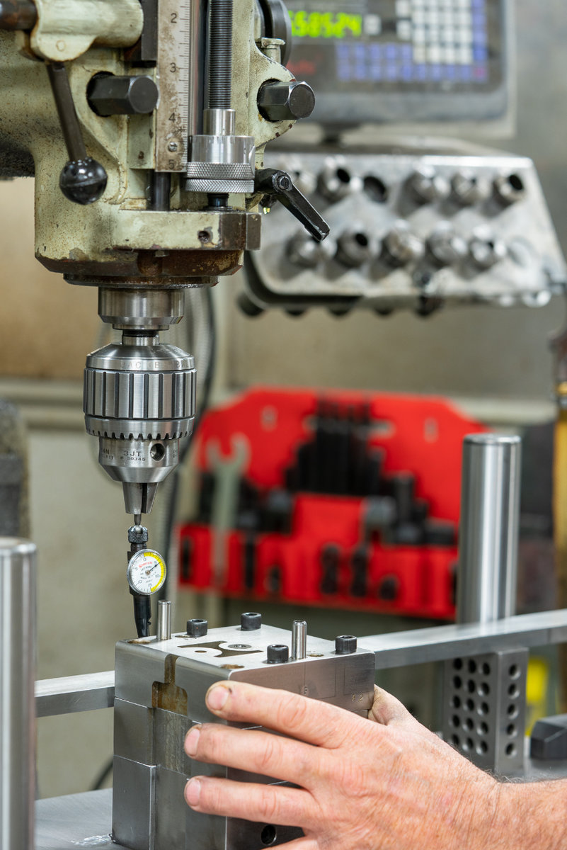 Knowledgeable tool and die machinist operating a metal stamping die.